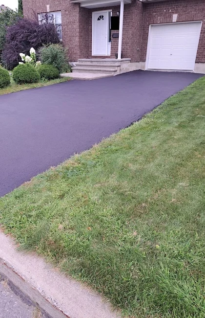 Une entrée récemment installée avec de l'asphalte frais et lisse.